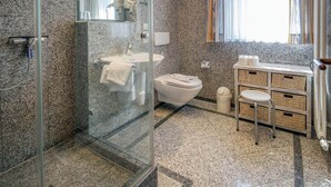 Ein modernes Badezimmer mit Duschkabine aus Glas, einem weißen Waschbecken und einer Toilette.