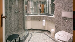 A modern bathroom with a glass-enclosed shower, a sink with a marble countertop, and a toilet with a towel. - Budget Ferienwohnung mit 1 Schlafzimmer und Balkon im Dachgeschoss (Ostseebad Binz)