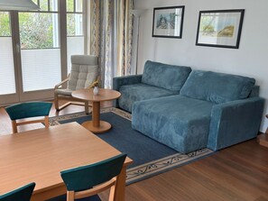 Un salon comprenant un canapé, un fauteuil, une table et un tapis.