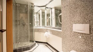A modern bathroom with a glass-enclosed shower, a large mirror, and a toilet with a towel. - Comfort apartment with 1 bedroom and balcony on the upper floor (Ostseebad Binz)