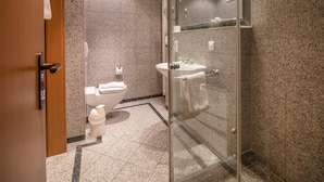 A modern bathroom with a glass shower enclosure, a toilet, and a sink. - Comfort apartment with 1 bedroom and terrace on the first floor (Ostseebad Binz)