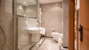 A modern bathroom with a glass-enclosed shower, a sink, and a toilet. - Comfort apartment with 1 bedroom and terrace on the first floor (Ostseebad Binz)