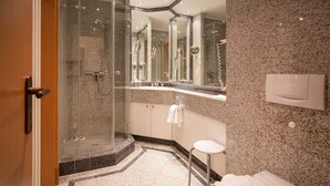 A modern bathroom with a glass-enclosed shower, a white toilet, and a marble-tiled floor. - Comfortplus vacation apartment with 1 bedroom and terrace on the first floor (Ostseebad Binz)