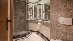 A modern bathroom with a glass-enclosed shower, a sink with a mirror, and a toilet. - Comfort apartment with 1 bedroom and balcony on the upper floor (Ostseebad Binz)