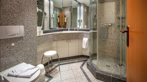 A modern bathroom with a granite countertop, a glass-enclosed shower, and a toilet. - Komfortplus Ferienwohnung mit 1 Schlafzimmer und Balkon im Dachgeschoss (Ostseebad Binz)