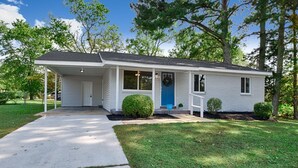 A single-story house with a front porch, a blue door, and a mailbox.