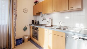 Una cucina moderna con mobili in legno, un lavello in acciaio inossidabile e una lavastoviglie.