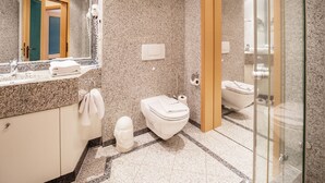 A modern bathroom with granite countertops, a toilet, a bidet, and a glass shower enclosure. - Comfort apartment with 1 bedroom and terrace on the first floor (Ostseebad Binz)