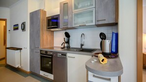 Eine moderne Küche mit Edelstahlgeräten, einem Backofen, einer Spülmaschine und einer Mikrowelle.