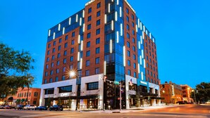 A tall, modern hotel with "Renaissance" branding, featuring a prominent glass facade and a corner location at a city intersection. - Renaissance Oklahoma City Downtown Bricktown Hotel (Oklahoma City)