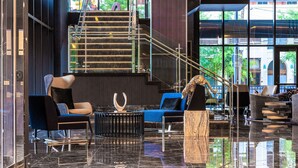 A modern lobby with a marble floor, a staircase, and contemporary seating arrangements. - Renaissance Oklahoma City Downtown Bricktown Hotel (Oklahoma City)