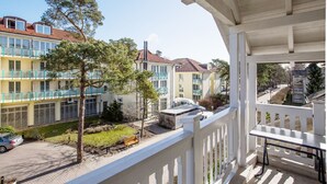 Un balcone con vista su un edificio a più piani con balconi e un'area giardino.
