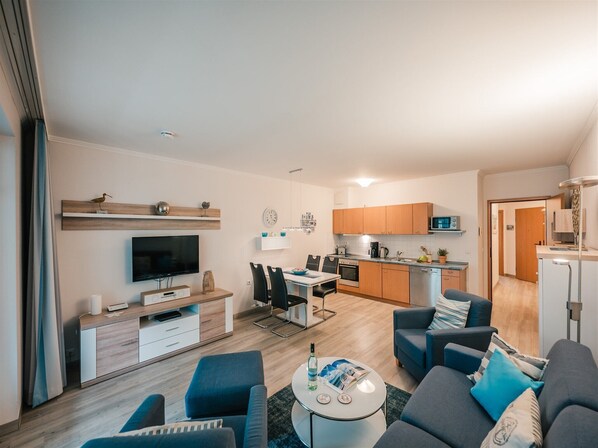 Een modern appartement met een woonkamer, eethoek en keuken.