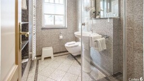 Een badkamer met toilet, wastafel en douche.
