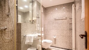 A modern bathroom with a glass-enclosed shower, a white toilet, and a sink. - Comfort apartment with 2 bedrooms and balcony on the upper floor (Ostseebad Binz)