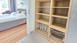 Hotellihuone, jossa on sänky, puinen vaatekaappi ja ikkuna, jossa on verhot.
