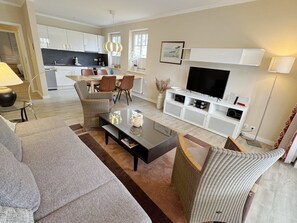 A modern living room with a sofa, coffee table, and TV stand.