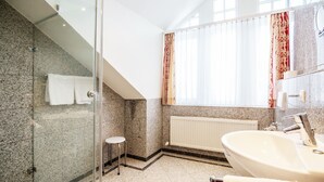 A modern bathroom with a glass shower enclosure, a white sink, and a large mirror. - Comfort apartment with 2 bedrooms and balcony on the top floor (Ostseebad Binz)