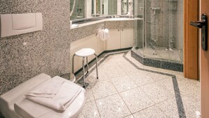 A modern bathroom with a toilet, a sink, a mirror, and a shower. - Comfortplus vacation apartment with 1 bedroom and terrace on the first floor (Ostseebad Binz)