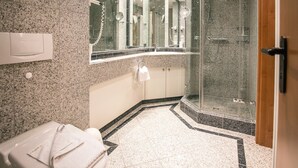 Un bagno moderno con doccia vetro-murata, un water e un mobile lavabo con specchio.