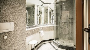 A modern bathroom with a granite countertop, a glass-enclosed shower, and a vanity with a mirror. - Comfort apartment with 1 bedroom and terrace on the first floor (Ostseebad Binz)