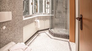 A modern bathroom with a granite countertop, a glass shower enclosure, and a large mirror. - Komfort Ferienwohnung mit 1 Schlafzimmer und Balkon im Obergeschoss (Ostseebad Binz)
