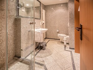 Ein modernes Badezimmer mit einer Duschkabine, einem Waschbecken und einer Toilette.