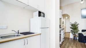 Een moderne keuken met witte kastjes, een ingebouwde magnetron en een spoelbak.