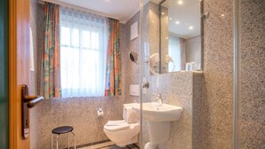 Une salle de bain équipée de toilettes, d’un lavabo et d’une douche.