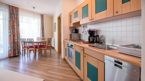 Une cuisine moderne avec des meubles en bois, un évier en acier inoxydable et un lave-vaisselle Siemens.