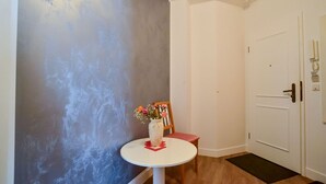 A hallway with a white door, a small round table with a vase of flowers, and a chair. - Comfort plus apartment with 2 bedrooms and balcony on the upper floor (Ostseebad Binz)