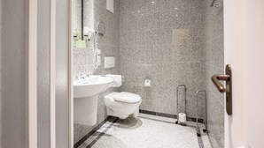 A bathroom with a white sink, toilet, and shower area. - Comfort plus apartment with 2 bedrooms and balcony on the upper floor (Ostseebad Binz)