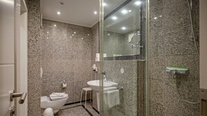 A modern bathroom with a glass shower enclosure, a white sink, and a toilet. - Comfort apartment with 1 bedroom and terrace on the first floor (Ostseebad Binz)