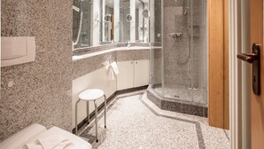 A modern bathroom with a glass-enclosed shower, a vanity with a mirror, and a toilet. - Comfort apartment with 1 bedroom and balcony on the upper floor (Ostseebad Binz)