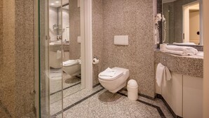 A modern bathroom with a glass shower enclosure, a toilet, and a sink area with a towel rack. - Comfortplus vacation apartment with 1 bedroom and terrace on the first floor (Ostseebad Binz)