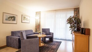 Een moderne woonkamer met een bank, twee fauteuils, een salontafel en een tv-meubel.