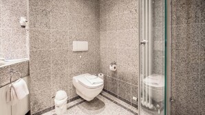 A modern bathroom with a toilet, bidet, and glass shower enclosure. - Comfort apartment with 1 bedroom and balcony on the top floor (Ostseebad Binz)