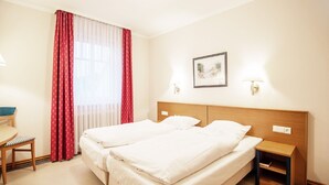 A hotel room with two beds, a desk, and a chair. - Comfort apartment with 1 bedroom and balcony on the upper floor (Ostseebad Binz)