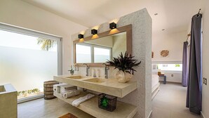 Een moderne badkamer met een grote spiegel, twee wasbakken en een douchegedeelte.
