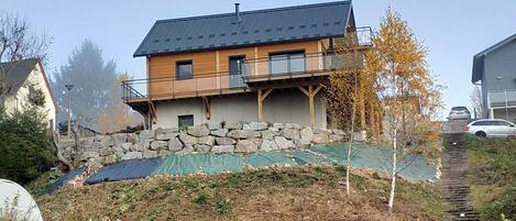 A two-story house with a stone foundation and a wooden upper level.