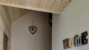 Een houten trap met een hartvormige decoratie aan de muur en een letterkunstwerk waarop 'HOME' staat.