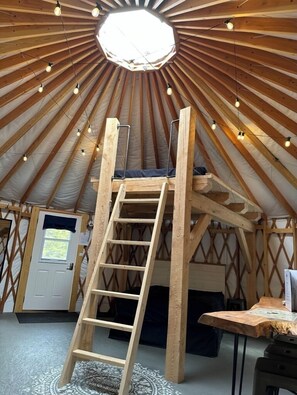 Een houten interieur met een ladder, een deur en een tafel.