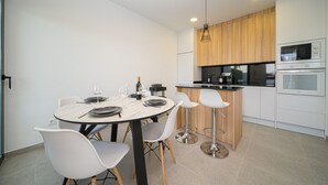 A modern kitchen with white cabinets, a wooden countertop, and stainless steel appliances. - Villa Camilla Roda Golf (Roda)