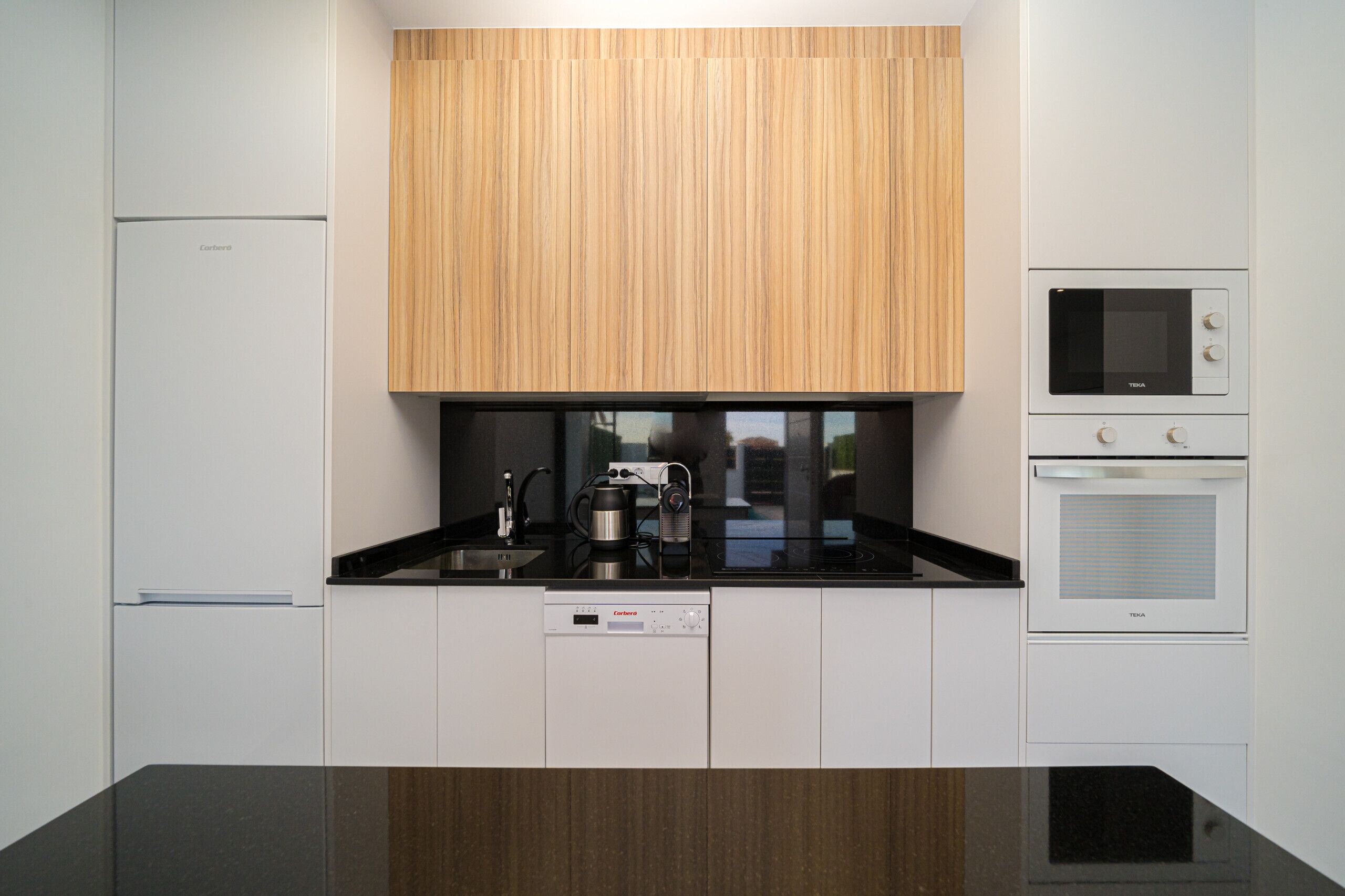 A modern kitchen with a built-in microwave, oven, and dishwasher.