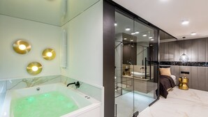 A modern bathroom with a large bathtub, glass shower enclosure, and a vanity with a sink.