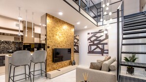 A modern living room with a flat-screen TV, a sofa, and a coffee table.