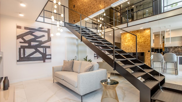 A modern interior with a staircase, a sofa, and a coffee table.