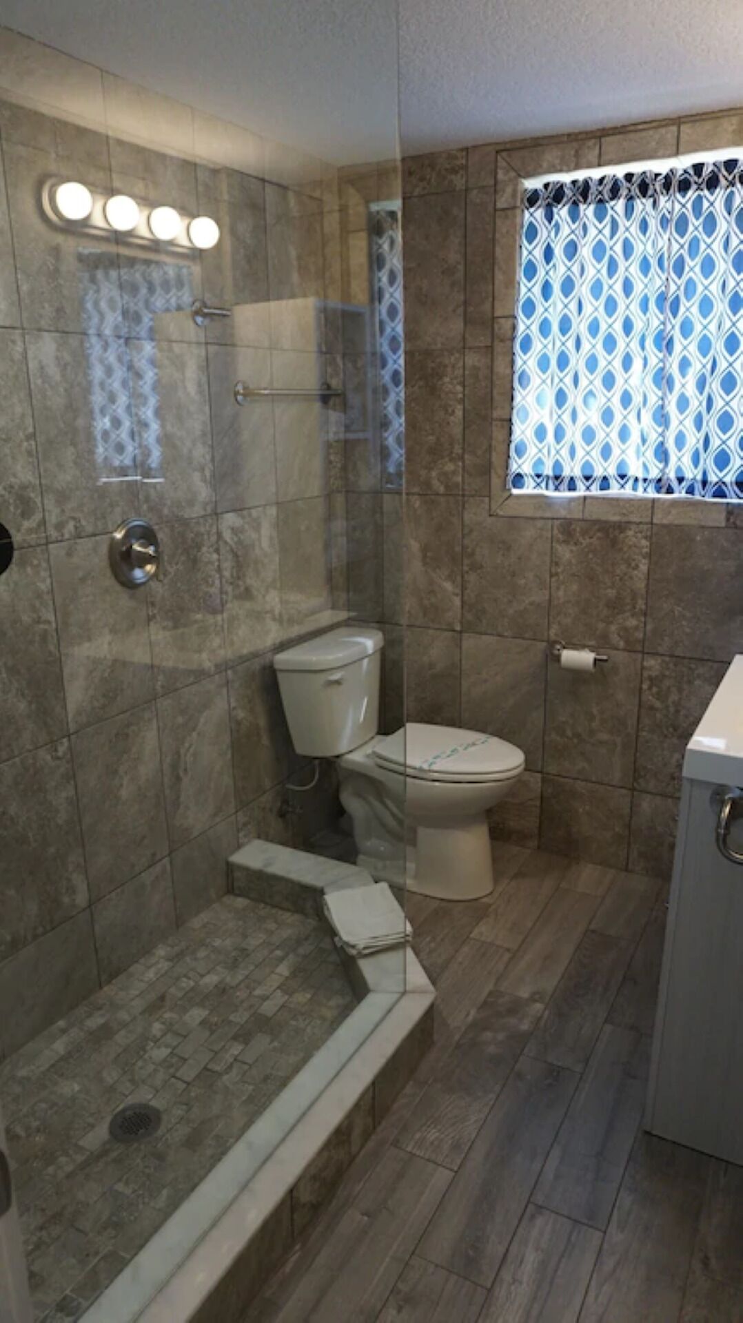 Ein Badezimmer mit Dusche, Toilette und Waschbecken.
