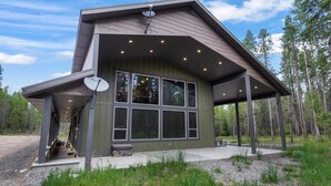A modern building with large windows, a covered porch, and satellite dishes. - Island Park Cabin with Private Dock on the Lake (Island Park)