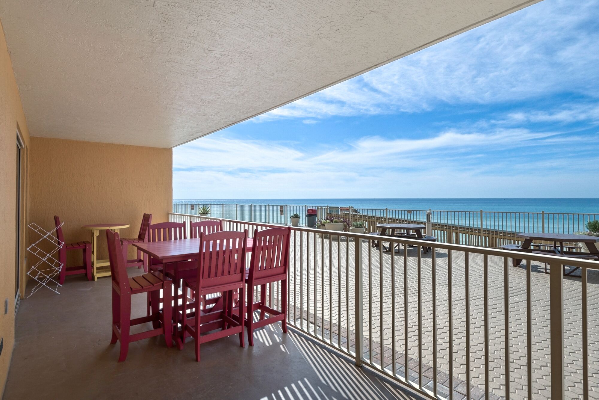 A balcony with a view of the ocean, featuring a table and chairs.